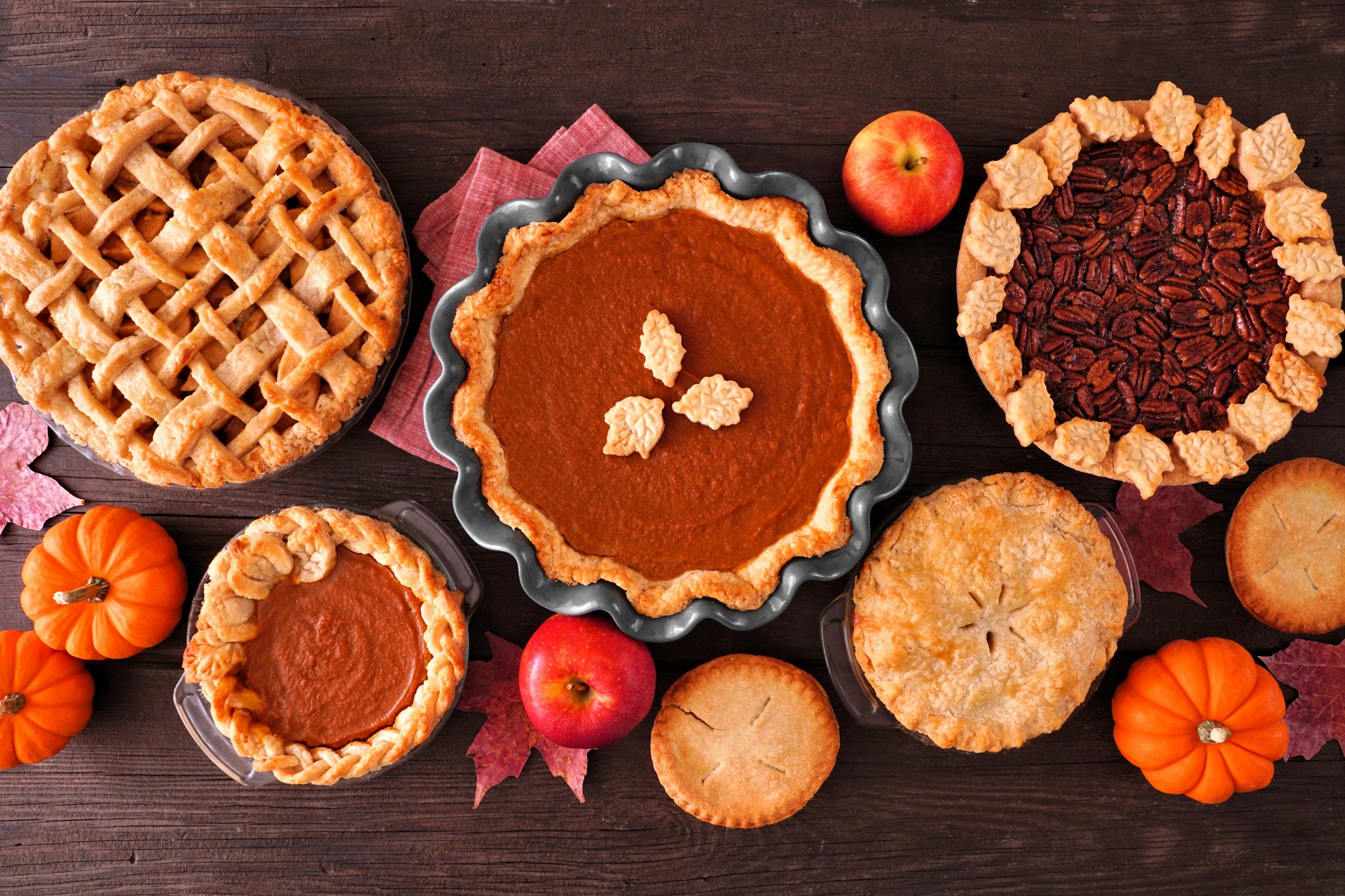 Assortment of homemade fall pies, table scene on dark wood