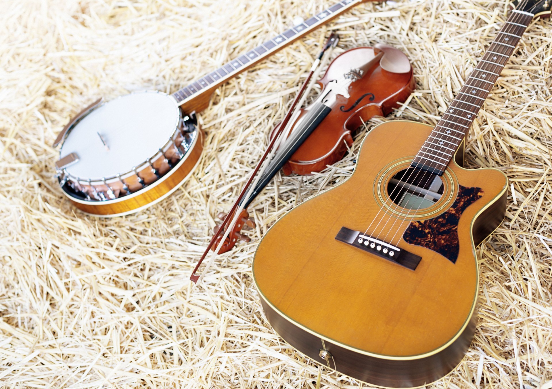 Banjo, acoustic guitar and fiddle on straw